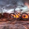 A brilliant sunset behind petroglyph rocks.