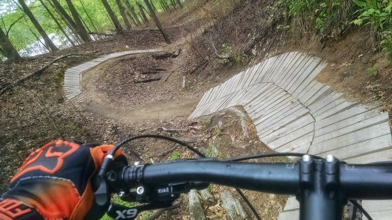 Riding into a wood and dirt coaster on the Green Loop.