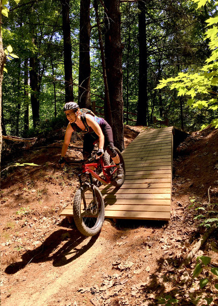 J. riding through wooden drop option on the Basic Training Skills Trail.