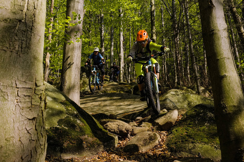 Riders navigate some of the rock slabs found near the bottom of the Wales trail.