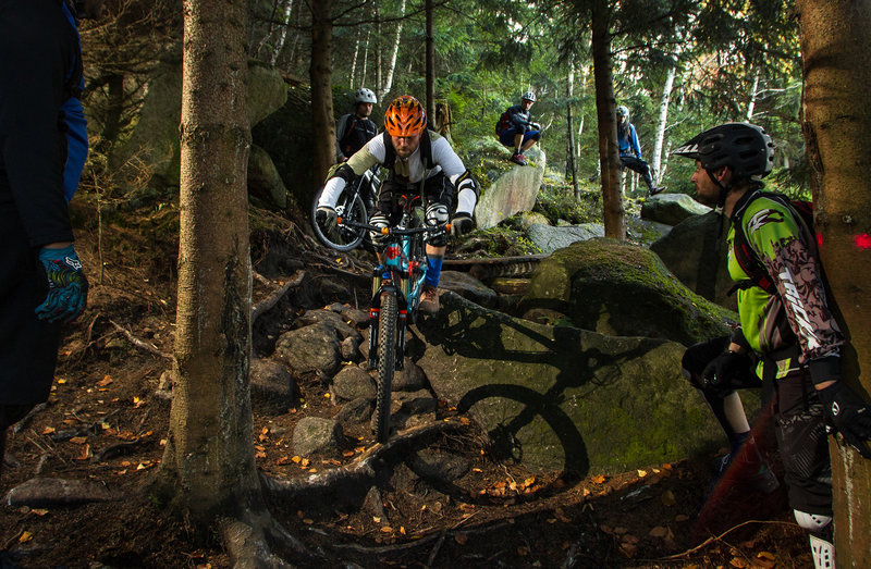 A rider takes a skills lesson on the rough Wales trail.