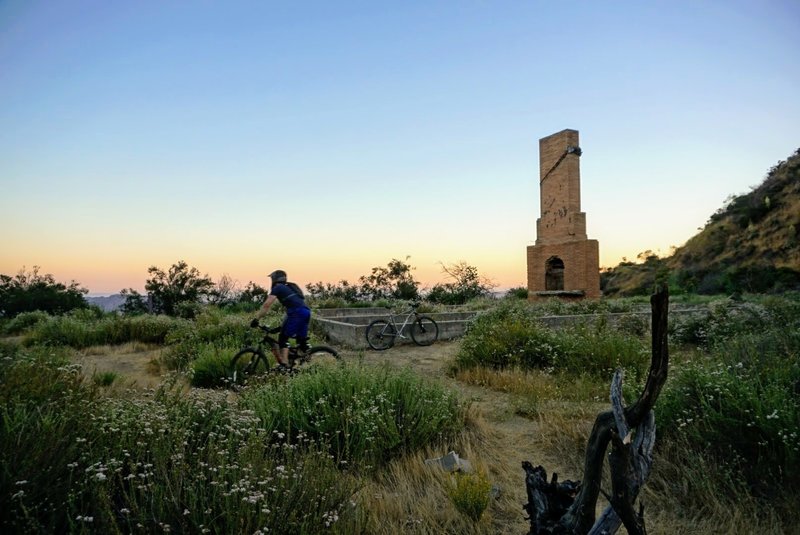 Sean cruises by the chimney and foundation that give Old Youth Camp/Boy Scout trail its name.