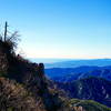 A faintly visible Carter, ignores the fantastic views as he rounds the corner into the Strawberry Peak Trail's downhill section. In the distance is the Lukens, Verdugos, and Santa Monica Mountain ranges.