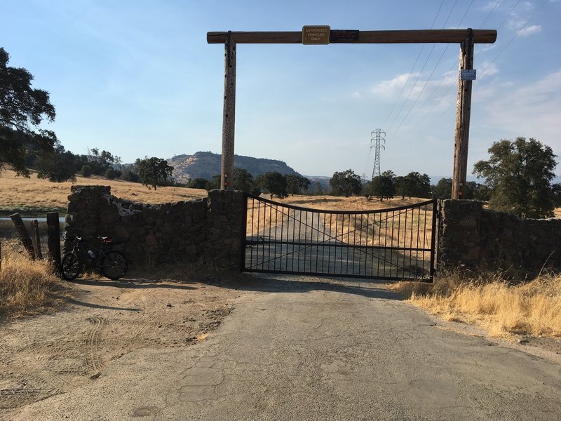 This is the gate at the top of the trail. It is locked. On the left, there is a narrow gap you can walk through and you have to lift your bike over your head to get through. Then start riding down the dirt road.