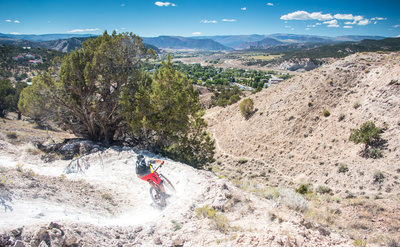 Railing high speed berms at the bottom of Redneck Ridge in Eagle with a view west down valley.