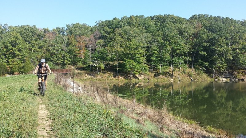 W riding along Crooked Creek Lake Dam at the end of the Crooked Creek Trail.