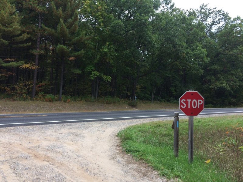 Crossing M-20 to the trailhead that is visible just to the left of the stop sign.