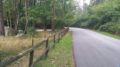 From the parking lot on the left, there a short descent on the road to reach the beginning of the trail.