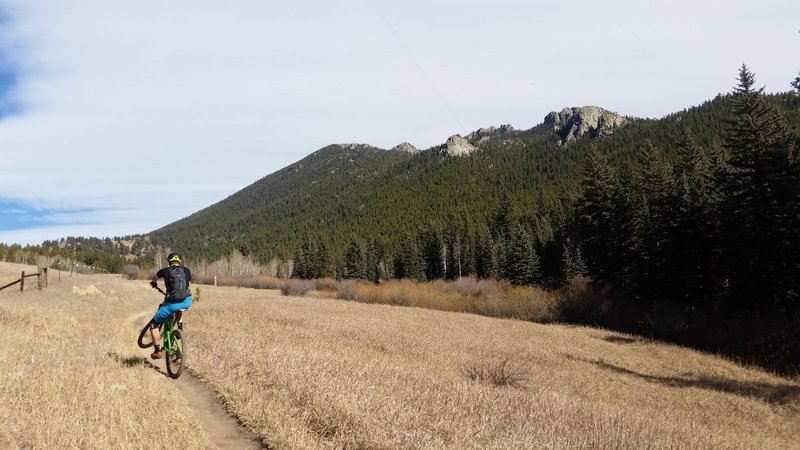 Chris pops a wheelie on the way up Mule Deer Trail with great views of the rocky ridgeline