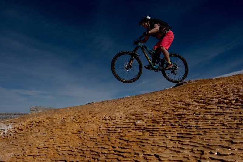 Lizz getting some air under her wheels while descending Good Times at White Mesa.