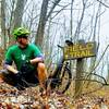 The trail sign near where Field Trail intersects with a paved road in Shawnee State Park.