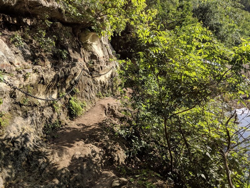 Chains along the side wall to keep hikers from falling. The ground can be very slippery around this area since it runs along the Barton Creek.