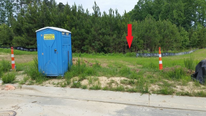 The Troy Woods Trail starts behind the black silt fence.