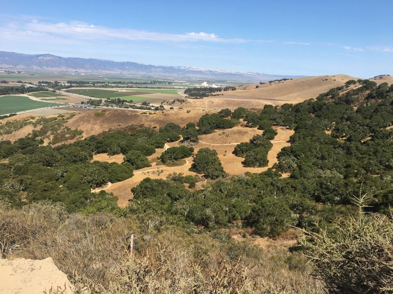 Trail 31 winds down toward Creekside Terrace in the middle of the photo.  The white buildings in background were built by Spreckels Sugar Co. and define the town of Spreckels.  Fremont Peak mountain range sets the background.