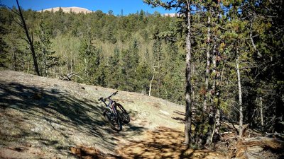 Pike's Peak tops above one of the massive granite boulders along the Lake Moraine trail. The trail has numerous A and B lines, truly a trail built by mountain-bikers for mountain-biking!