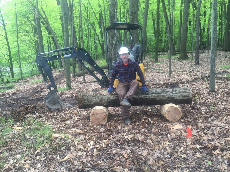 Building a new bench, "Greg's Rest", for a view of Winnewana Lake. Kevin Marzhal, Spectrum Trail Design machine operator.