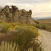 Riding down from Knob Point, the trail disappears behind blooming sage brush and big rock formations.