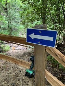 Please use caution here, as the trail doglegs left as it crosses the access road that drops off sharply. Access road has a fence across it and the trail goes hard left here!