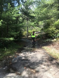 Andrew is biking on some rock.