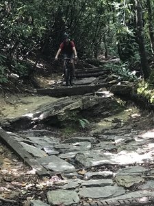 Lukas is biking down a rocky section.