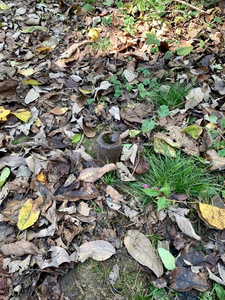 There's a piece of a metal pole sticking up in the middle of the trail. It's right before the last corner that turns left (heading east) coming out of the brush.