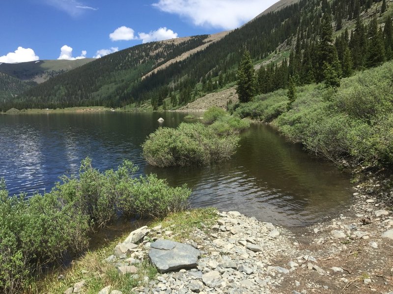 The road around Mirror Lake is submerged, requiring a hike-a-bike through dense brush.