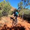 Riding down into a dip past a fork in the trail.