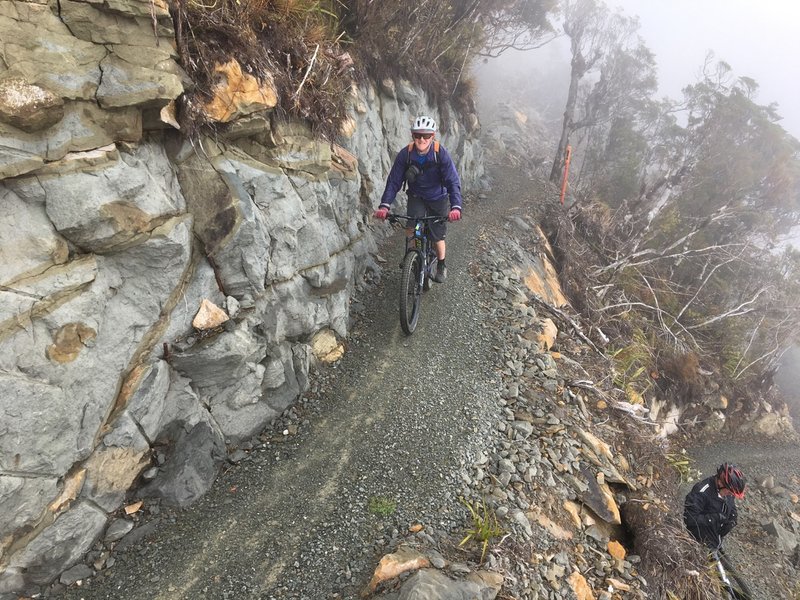 The trail clings to a rock bluff