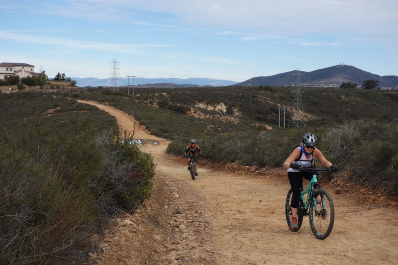 Mountain biking couple on the Duck Pond Connector. Black Mountain is 4.5 miles away at right side