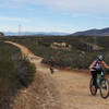 Mountain biking couple on the Duck Pond Connector. Black Mountain is 4.5 miles away at right side