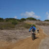 Mountain biker in Los Peñasquitos Canyon exercising his border collie at the end of Hopper