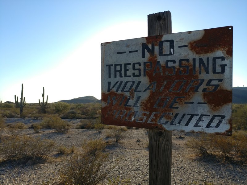 No Trespassing sign at private inholding boundary (sign was in dirt and held up for photo). Please respect private landowner boundaries!