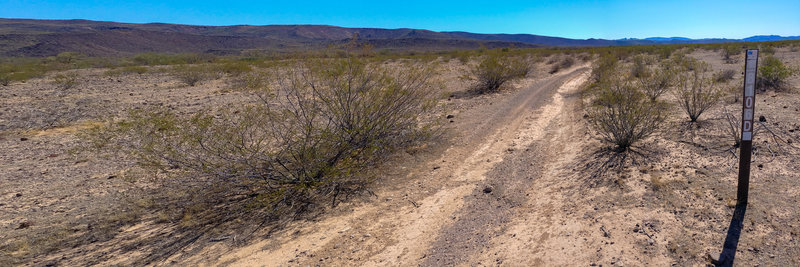 Looking east down Saikil (8106A) at the trail marker for 8106D that heads north. Composite of 2 images (slightly distorted).