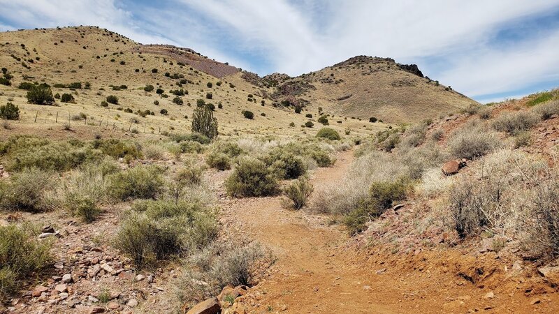 The trail hugs the edges of the watershed towards the eastern trailhead.