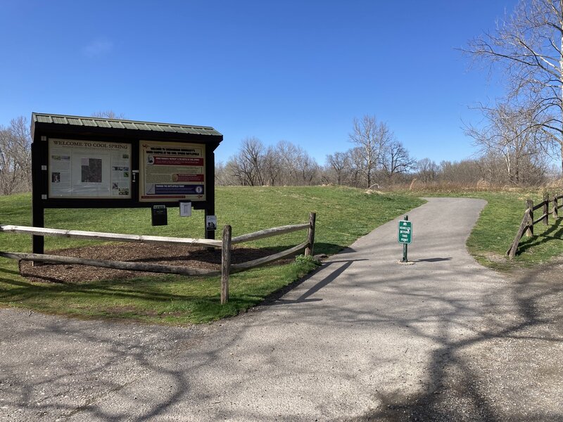 Paved path towards the entrance of the trail. You can go left or right, but not on the gravel road.