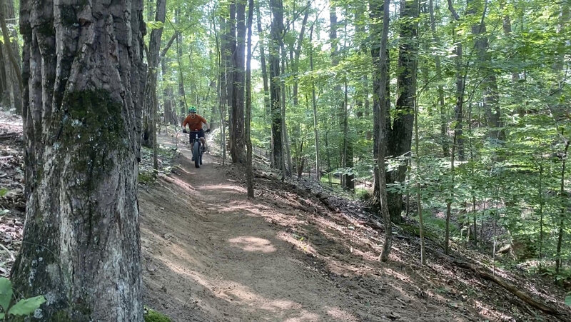 Putting first wheels on "up Side". MORE volunteer Dave Evans checks the trail for flow - gets to ride the fresh bench for the first time :-)