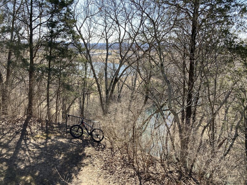 View above the river, across the pond and to the farm from the river overlook on the wooded singletrack