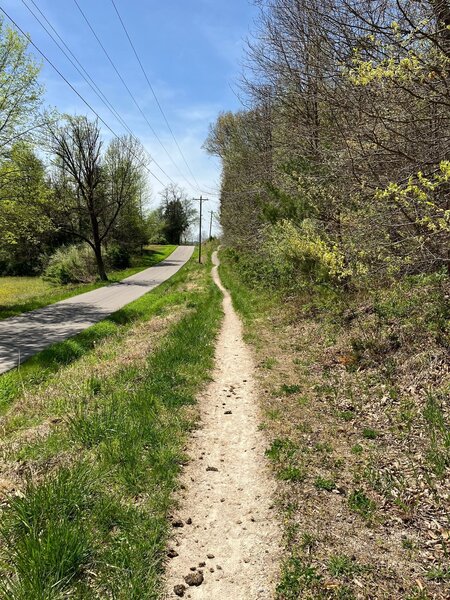 It goes along the rode, but this section is fun to ride counter clockwise.