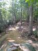 Downhill leading to a rock feature that leads into a steep banked turn.