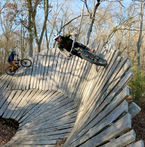 Mike Samson and Jerome Freppert riding the large wall berm into the drop zone.