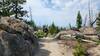 A mountain bike rider cruises down between the granite boulders of the East Ridge.