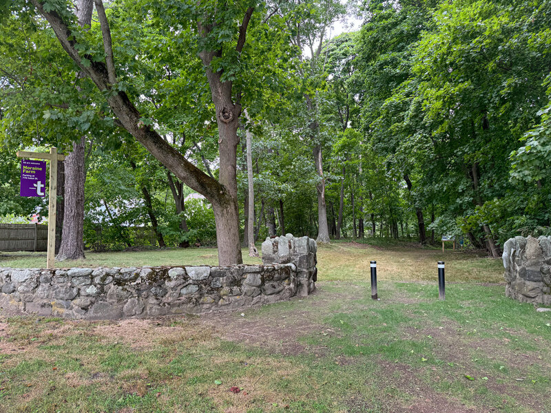 Entry's stone wall, map kiosk nearby.