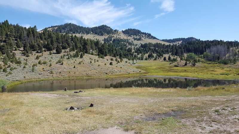 A small water reservoir beside the Norton Gulch Trail is surrounded by beautiful scenery.