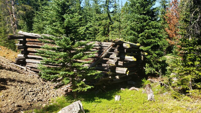 The ruins of an old log cabin lies next to a pile of mine tailings, remnants of the old Iron Mine.