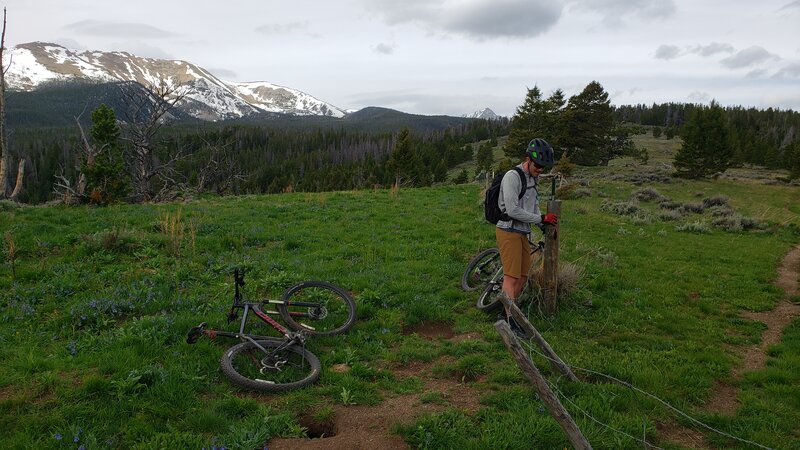 A mountain biker opens the gate near the top of Trail #303.