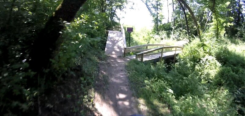 Continue flow trail to the right. "Back to the High Life" climb trail to the left.