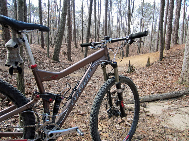 My bike stares wistfully down the trail, dreaming of sweeping berms and catching air with reckless abandon.