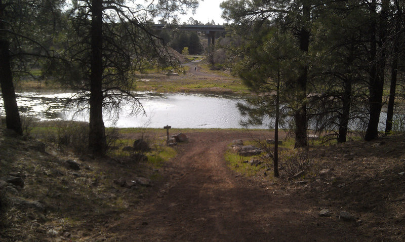 Wind your way around this pond to get on the Arizona Trail to Fisher Point. That is I-40 in the background.